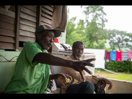 Winston Blake (left) speaks on the numerous fabled tales of Copper Hole in Georgia, St Thomas. Looking on is Eccleston Johnson, who also had stories about the water spot.