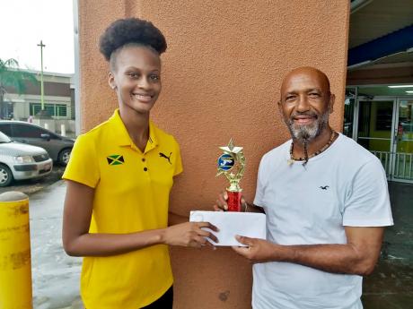 Clarendon businessman Andrew ‘Nazi’ Mattrasingh presents a scholarship package to Ruddayne Peters. 