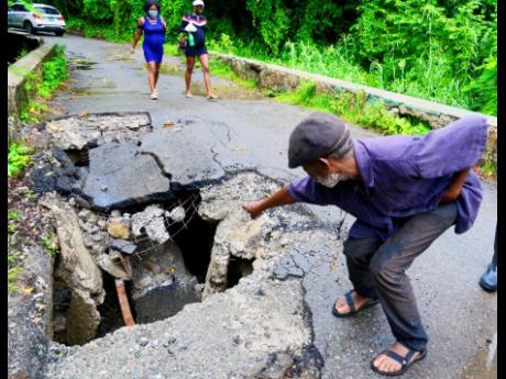 Credit: File Llandewey resident Phillip Henry points to a spot in the bridge that was ignored by the authrorities for two years before the structure collapsed earlier this month.
