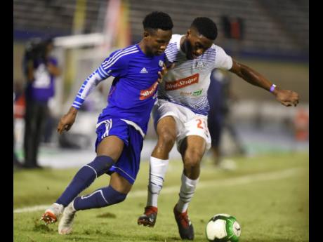 Mount Pleasant’s Cardel Benbow (left) and Emelio Rousseau of Portmore United in a tussle for  the ball in a semi-final of the National Premier League on April 15, 2019.