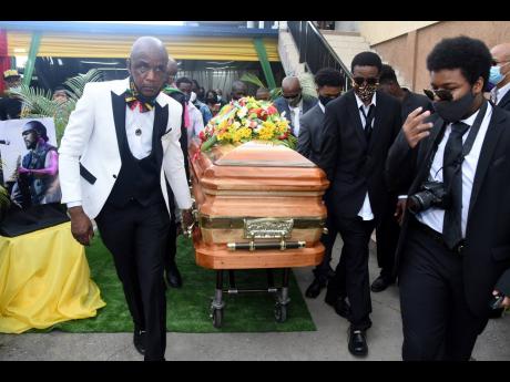 Peter Perry (left) CEO of Perry’s Funeral Home leads the  pall bearers in carrying the casket containing the body of the late Frederick ‘Toots’ Hibbert.