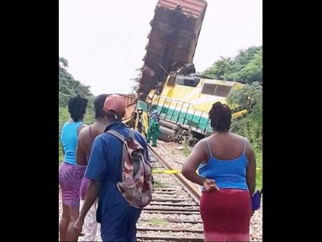Curious onlookers view the derailed train. The driver is reportedly okay after the crash.