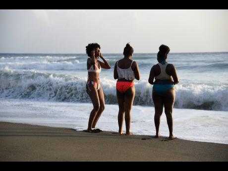 These three ladies enjoy the evening breeze while chilling out at Bob Marley Beach, located in Bull Bay, St  Andrew.