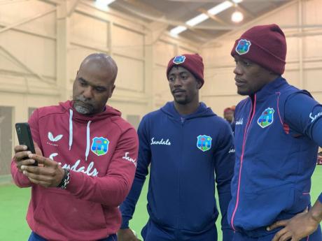 West Indies leg spinner Hayden Walsh Jnr (centre) look over video footage after practice with assistant coach Andre Coley (left) and teammate Nkrumah Bonner in New Zealand.