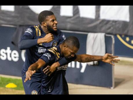 Philadelphia Union’s Mark McKenzie leaps upon teammate Cory Burke after he scored the go-ahead and eventual game-winning goal against the Chicago Fire during the second half of an MLS match, Wednesday, October 28, 2020.