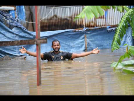 During recent flood rains, Dwayne McKoy, a resident of Grants Crescent in Hampton Green, Spanish Town, wades through chest-high floodwaters to the rear of his home, from which he operates a furniture workshop. McKoy said that flooding has been a long-standing issue in the Spanish Town community. 