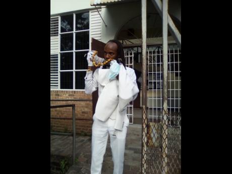 Credit: Rasbert Turner L.A. Lewis blows the abeng outside the courthouse.