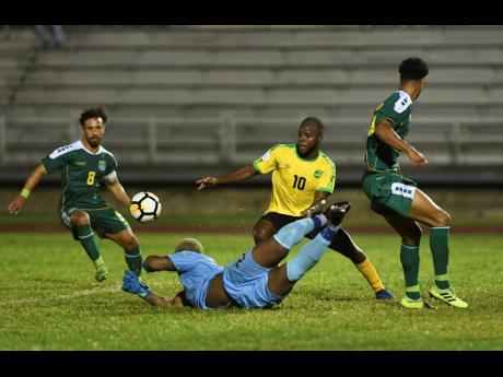 Jamaica’s Javon East (second right) takes on Guyana’s Samuel Cox (left), Quillan Roberts (second left) and Terrence Vancooten during a Concacaf Nations League match at the Montego Bay Sports Complex on Monday, November 18, 2019.