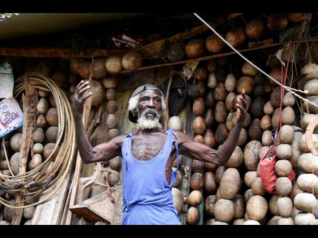 Eden Malcolm stands in his home as he explains how hard it is for the few residents in the rural St Andrew community of Bito to travel to and from more built-up areas of St Andrew.