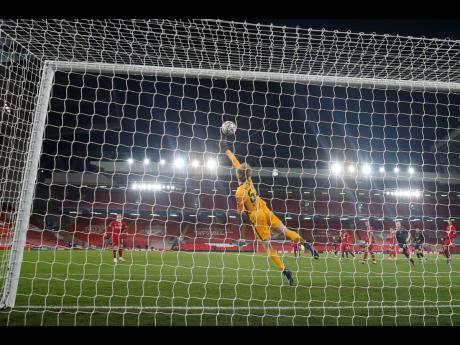 Liverpool’s goalkeeper Caoimhin Kelleher saves as he tips the ball over the goal during the Champions League group D soccer match between Liverpool and Ajax at Anfield stadium in Liverpool, England, yesterday.