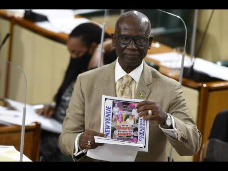 Local Government Minister Desmond McKenzie holds up a flyer for an event advertised for today, that has not received the necessary permits from the Kingston and St Andrew Municipal Corporation. 