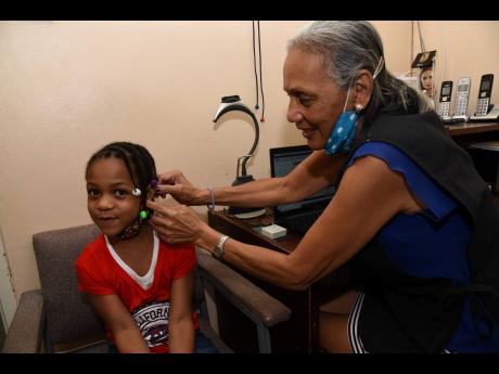 Jaydi-Ann Chambers is fitted with her hearing aids by Dr Georgia Beavers. The accessories, valued at $350,000, were paid for by Canopy Insurance Limited.