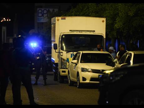 Members of a Jamaica Constabulary Force’s specialised operations team detaining deejay Tommy Lee Sparta and other men on Monday evening on Holborn Road, New Kingston.