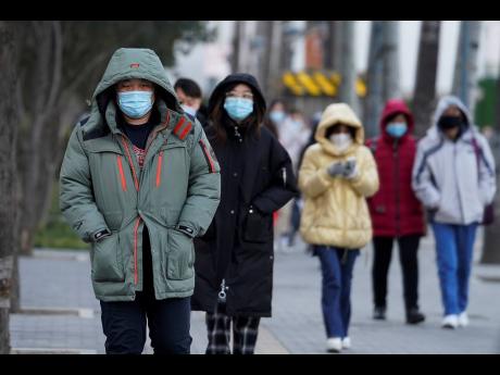 Credit: AP People wearing face masks to help curb the spread of the coronavirus head for work during the morning rush hour in Beijing, China. Jamaica’s Shaquella Bartley has been studying in the Asian country since 2017.