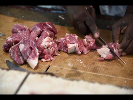 Goat meat being prepared for a customer at the meat market in Cross Roads, Kingston, yesterday.