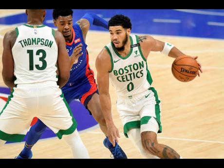 Boston Celtics forward Jayson Tatum drives to the basket against the Detroit Pistons during the first half of an NBA basketball game yesterday.