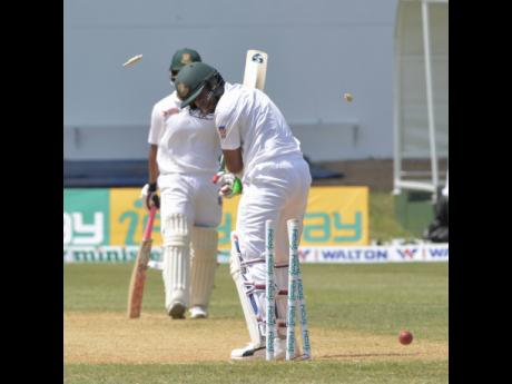 FILE
Shakib Al Hasan (right) looks back to see his stumps shattered after he was bowled by Jason Holder on the second day of the second Test match between the West Indies and Bangladesh at Sabina Park in 2018.