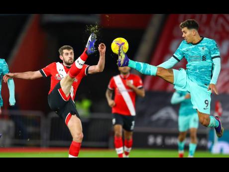 Southampton’s Jack Stephens, left, and Liverpool’s Roberto Firmino compete for the ball during the English Premier League match between Southampton and Liverpool at St Mary’s Stadium, Southampton, England, yesterday.