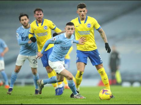 Manchester City’s Phil Foden (centre) in action during their English Premier League match against Brighton and Hove Albion at the Etihad Stadium in Manchester, England, yesterday.
