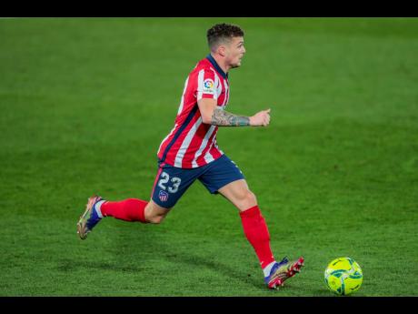 FILE - In this Saturday, December 12, 2020 file photo, Atletico Madrid’s Kieran Trippier runs with the ball during the Spanish La Liga soccer match between Real Madrid and Atletico Madrid at the Alfredo Di Stefano stadium in Madrid, Spain. 