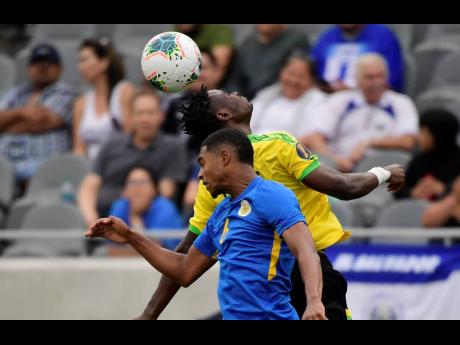 Curaçao midfielder Michael Maria (front) and Jamaica midfielder Andre Lewis try to head the ball in a Concacaf Gold Cup match in June 2019 in Los Angeles. 
