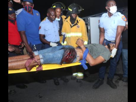 Kemar Archer is carried by fire and medical personnel to the ambulance.