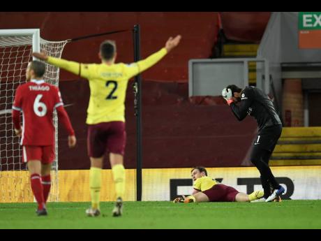 Liverpool's goalkeeper Alisson, right, reacts after giving out a penalty to Burnley's Ashley Barnes.