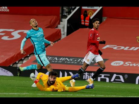 Manchester United’s Marcus Rashford( right) reacts after scoring his side’s second goal of the game during the English FA Cup 4th round match against Liverpool at Old Trafford in Manchester, England, yesterday.