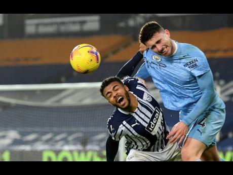Manchester City’s Aymeric Laporte (right) duels for the ball with West Bromwich Albion’s Hal Robson-Kanu during the English Premier League match between West Bromwich Albion and Manchester City at the Hawthorns stadium in West Bromwich, England, yesterday.