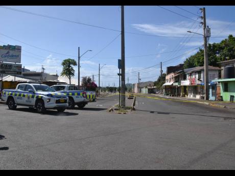 Credit: Errol Crosby Police cordon the crime scene where well-known west Kingston figure Harry McLeod was killed yesterday morning.