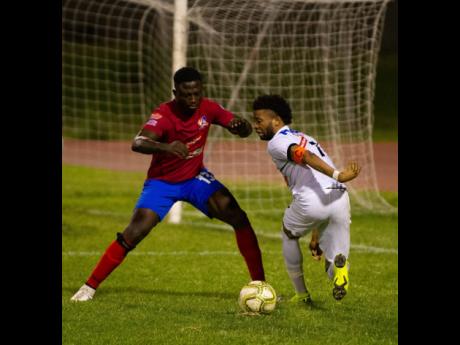 Dunbeholden’s defender Damarley Oliverstays (left) closes is on Cavalier’s Kaheem Parris in their Red Stripe Premier League encounter at Stadium East on Sunday,, December 16, 2018.