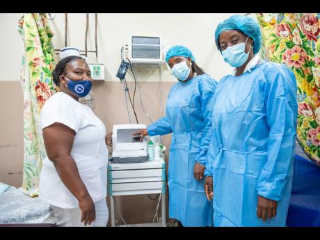Sister Janice Daley (left), acting maternity ward manager, Savanna-la-Mar Hospital, and Tanesia Tomlinson (right), hospital administrator speak with Carla Drummond, branch manager, Sagicor Bank, Savanna-la-Mar branch, about the benefits of a newly donated patient monitor. The equipment was among items donated to the hospital’s maternity ward from funds raised in the 2020 staging of the Sagicor Sigma Corporate Run.
