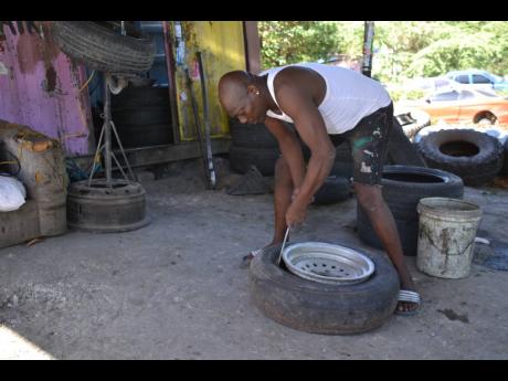Constantine Thompson works on a tyre at his shop in Bull Bay.