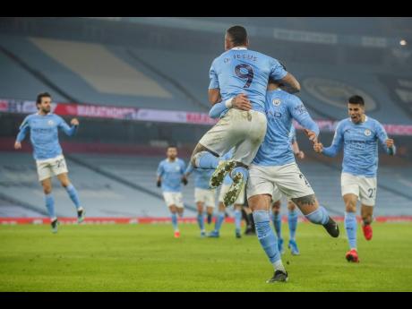 Manchester City players celebrate after scoring their team second goal during the English Premier League match between Manchester City and Wolves at the Etihad stadium in Manchester, England, yesterday.
