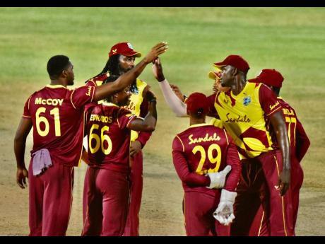 West Indies players huddle as they celebrate taking a wicket against Sri Lanka in the first match of the T20I series yesterday.