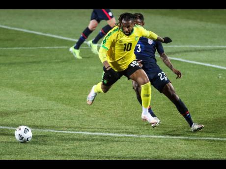 Jamaica's Kasey Palmer, foreground, duels for the ball with USA's Kellyn Acosta during  the international friendly soccer match between USA and Jamaica at SC Wiener Neustadt stadium in Wiener Neustadt, Austria, Thursday, March 25, 2021. 