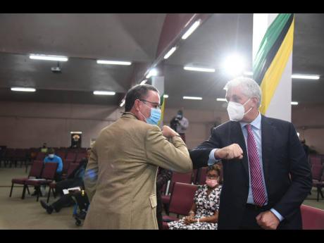 Minister of Energy, Science and Technology, Hon Daryl Vaz (left), greets Chief Executive Officer, Digicel Caribbean & Central America, Oliver Coughlan, at Digicel Jamaica’s 20th Anniversary Church Service, held at the Fellowship Tabernacle Church in Kingston yesterday.