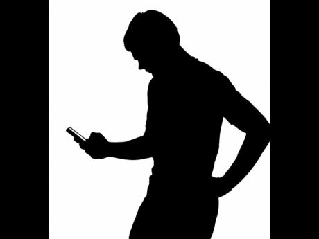 Silhouette of a male texting on smartphone. 