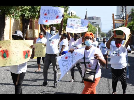 Scores of protesters demonstrate on Duke Street in Kingston near Gordon House yesterday, taking a stand to publicly denounce violence against women. 