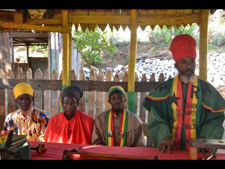 Credit: Errol Crosby Priest Christopher Morant (right) speaks during a ceremony held at Bobo Hill in St Andrew on Wednesday. Looking on are other Rastafarian priests of the Bobo Shanti order.