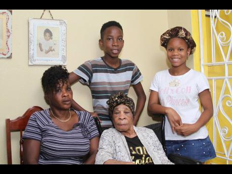 Eleather Richards, of Victoria, Clarendon, celebrated her 100th birthday on April 14. Here she relaxes in the company of Audrey Ricketts, granddaughter (left), Rickell Lindsay, great-great-grandson, and Colleen McPherson, great-granddaughter.