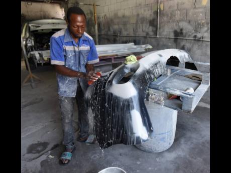 Credit: Ian Allen Odane Green washes a car bumper in preparation for spraying.
