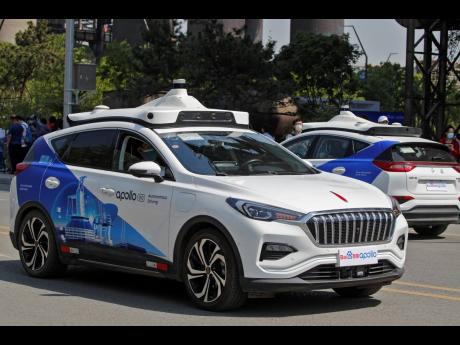 Baidu Apollo Robotaxis move on a street at the Shougang Park in Beijing yesterday.