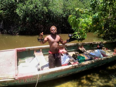 Boat captain Clive Campbell displays Donovon Haywood's diving gears whic were retrieved from the sea after he was attacked a shark.