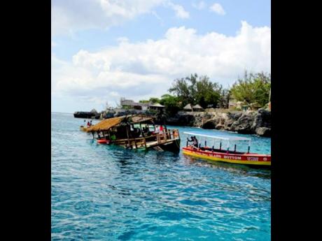 The thatched ‘party boat’ (left) that capsized off the Negril coastline on the weekend. 