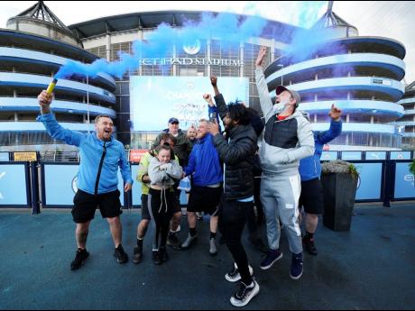 Manchester City supporters celebrate outside the Etihad Stadium in Manchester, England, on Tuesday after their team clinched the English Premier League title. 