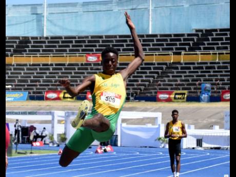 St Jago High School’s Balvin Israel in action in the Class Two Boys long jump yesterday.