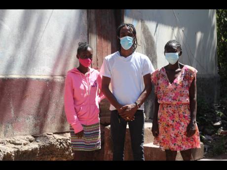 Donet Williams (right) and daughter Denicka Morgan (left), stand in front of their current dwelling with Khacy ‘Official Boss’ Mohammed. 