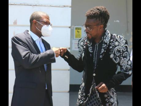 Beenie Man (right) and his attorney Roderick Gordon outside the  St Elizabeth Parish Court yesterday.