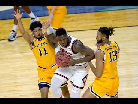 Illinois’s Kofi Cockburn (centre) is pressured by Drexel’s Camren Wynter (11) and Tim Perry Jr during a first round NCAA college basketball  game on March 19, 2021.